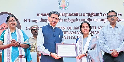 Governor RN Ravi felicitates a student during Bharathiar’s 144th birth anniversary celebration held at the Lok Bhavan in Chennai on Thursday