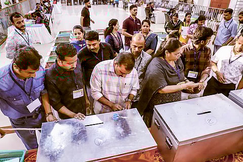 Polling officials open ballot boxes during counting of votes for the Kerala local body elections, in Kozhikode,