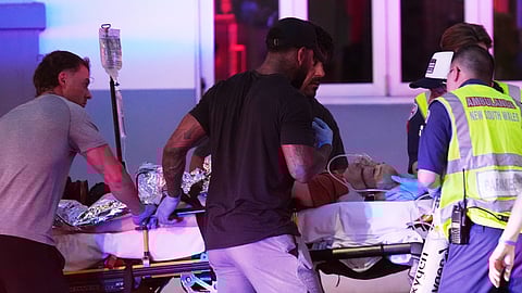 Emergency workers transport a person on a stretcher after a reported shooting at Bondi Beach in Sydney, Sunday, Dec. 14, 2025.