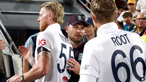 England’s team coach Brendon McCullum (C) shakes hands with team captain Ben Stokes (L) and Joe Root after day four of the second Ashes cricket Test match between Australia and England at The Gabba in Brisbane on December 7, 2025.