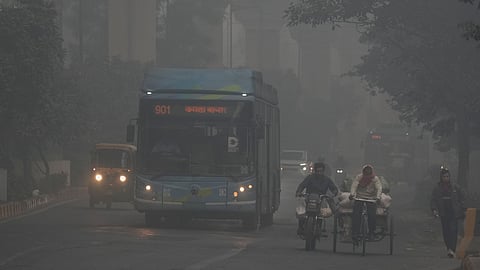 Vehicles move on a road amid low visibility due to a layer of smog in New Delhi, Sunday, Dec. 14, 2025.