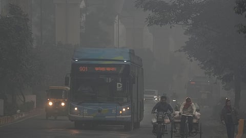 Vehicles move on a road amid low visibility due to a layer of smog, in New Delhi, Sunday, Dec. 14.