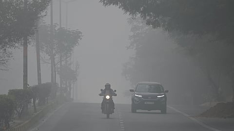 Commuters drive amid heavy smog in New Delhi on Monday.