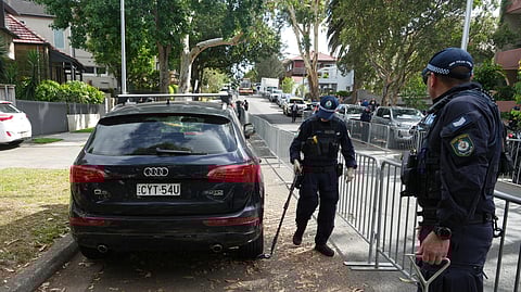 Police perform a sweep outside a synagogue in Bondi on Wednesday, Dec. 17, 2025, in Sydney, Australia, before the funeral of Rabbi Eli Schlanger, a victim in the Bondi Beach mass shooting.