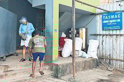 Customers buying liquor from the Tasmac shop near Medavakkam bus stop on Wednesday morning 