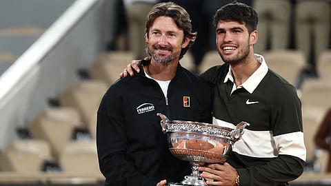 Spain's Carlos Alcaraz poses with his Spanish coach Juan Carlos Ferrero (L) after winning against Italy's Jannik Sinner at the end of their men's singles final match on day 15 of the French Open tennis tournament on Court Philippe-Chatrier at the Roland-Garros Complex in Paris on June 8, 2025.