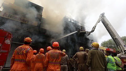 Firefighters try to douse the fire that broke out inside a showroom in Lajpat Nagars Central Market in New Delhi on Saturday.
