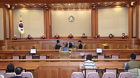 Kim Sang-hwan, top center, chief justice of the Constitutional Court, and the court's other justices attend a hearing to deliver a verdict on impeached police chief Cho Ji-ho at the court in Seoul, South Korea, Thursday, Dec. 18, 2025.