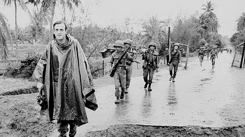 Associated Press correspondent Peter Arnett, left, marches with Vietnamese troops in Vietnam, Nov. 11, 1965.