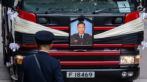 A picture of Ho Wai-ho, the firefighter who lost his life in the line of duty during the deadly fire at Wang Fuk Court on Nov. 26, is displayed on a hearse at a funeral parlor, in Hong Kong, Friday, Dec. 19, 2025. 