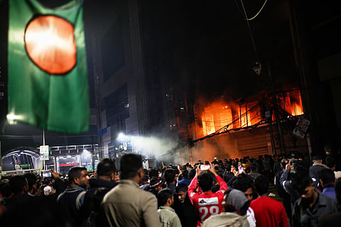 A crowd gathers near the premises of the Prothom Alo daily newspaper, which was set on fire by angry protesters after news reached the country from Singapore of the death of a prominent activist, Sharif Osman Hadi, in Dhaka, Bangladesh, Friday, Dec. 19, 2025.