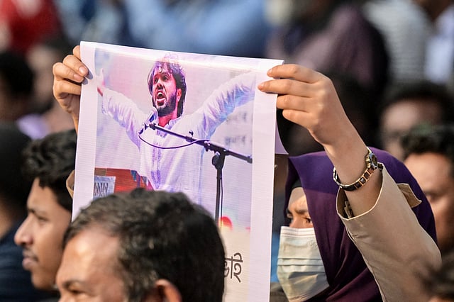 An activist holds a poster of Sharif Osman Hadi, senior leader of the student protest group Inqilab Mancha, who was shot outside a mosque, during a demonstration to condemn the attack in Dhaka on December 15, 2025.