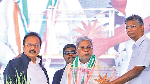 Public Works Minister Satish Jarkiholi presents a memento to CM Siddaramaiah at the launch of the Soil Health and Integrated Water Management Project in Belagavi taluk on Saturday