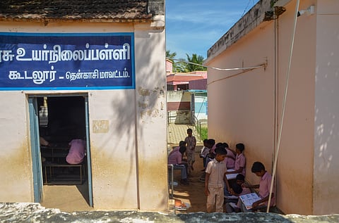 With insufficient classroom facilities, students are forced to sit and study in the narrow shaded corridor between buildings at Koodalur Government Higher Secondary School in Tenkasi.