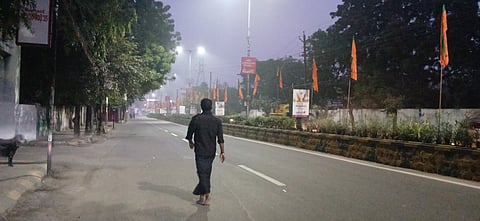 An Ayyappa devotee walks barefoot to the temple on Sunday morning on a fog covered road in the city