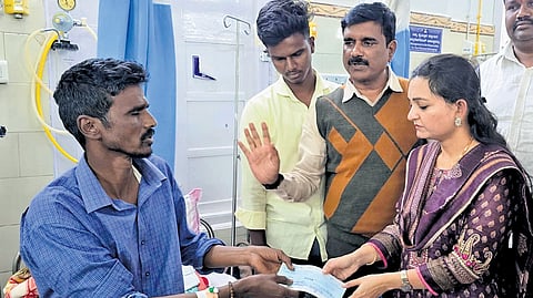 Dharwad DC Divya Prabhu hands over a cheque for Rs 5 lakh to Hanumantappa Doddamani, father of Vivekanand, at a private hospital in Hubballi on Tuesday.