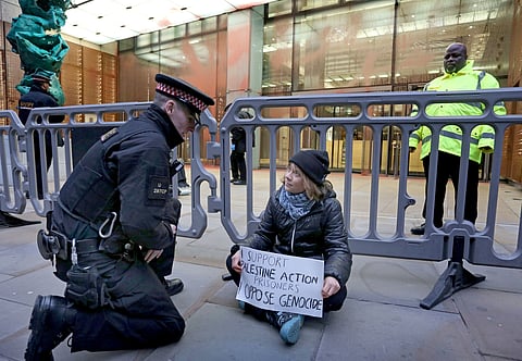 In this photo, released by 'Prisoners for Palestine' on Tuesday, Dec. 23, 2025, climate activist Greta Thunberg, center, sits in front of offices of Aspen Insurance in London, England, during a protest to support the Palestine Action protesters on hunger strike in prison.
