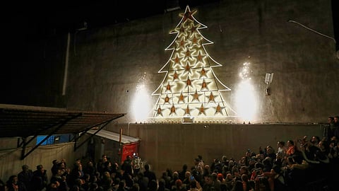 People attend the lighting of a Christmas tree at the Greek Orthodox Mar Elias Church, months after the church was the site of a deadly suicide bombing, in the Dweila neighborhood of Damascus, Syria, Tuesday, Dec. 23, 2025.