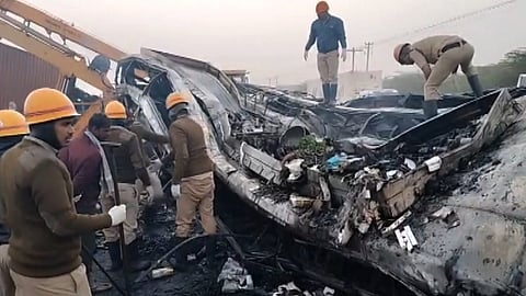 Security personnel at the site after a speeding truck crashed against a luxury sleeper bus, which caught fire under the impact, in Chitradurga, Thursday, Dec. 25, 2025.