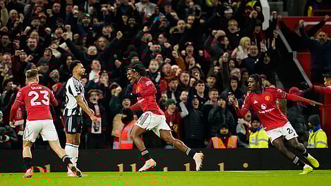 Manchester United's Patrick Dorgu, center, celebrates after scoring the opening goal during the EPL soccer match between Manchester United and Newcastle in Manchester, England, Friday, Dec. 26, 2025.