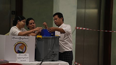 Election volunteers prepare to open a polling station on Sunday, Dec. 28, 2025, in Yangon, Myanmar.