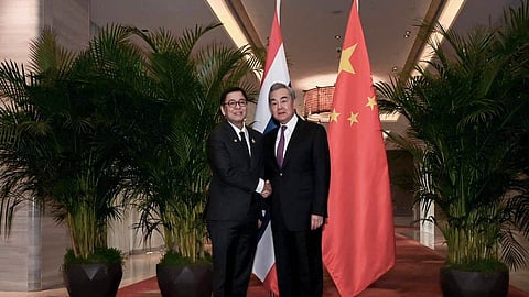 In this photo released by the Thai Ministry of Foreign Affairs, Thai Foreign Minister Sihasak Phuangketkeow, left, shakes hands with Wang Yi, Chinese Foreign Minister, in Yunnan Province, China, Sunday, Dec. 28, 2025.
