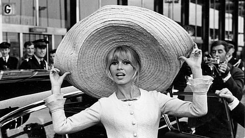 French actress Brigitte Bardot poses with a huge sombrero she brought back from Mexico, as she arrives at Orly Airport in Paris, France, on May 27, 1965.