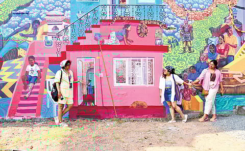 Actor Rima Kallingal, along with her friends, views a massive mural created by the eight-member artists’ collective ‘Trespassers’ at Cube Art Space on Mattancherry Bazaar Road, as part of the Kochi-Muziris Biennale 