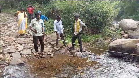 Officials inspecting the water streams for the upcoming iron bridge in Karuvelampatti in Kodaikanal taluk in Dindigul district.