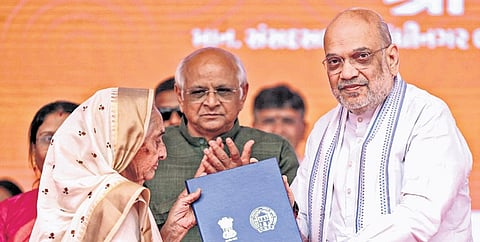 Amit Shah felicitates a beneficiary during an event in Ahmedabad.