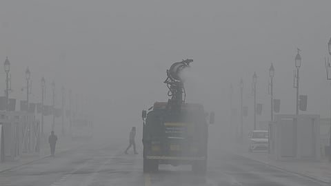 A vehicle sprays water using an anti-smog gun to curb air pollution on a smoggy winter morning in New Delhi on Monday.
