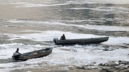 A man rides a boat in the polluted Yamuna river, in New Delhi.