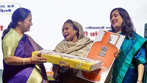  Delhi Chief Minister Rekha Gupta interacts with a beneficiary of Pradhan Mantri Ujjwala Yojana, in New Delhi on Saturday. BJP MP Bansuri Swaraj also present. 