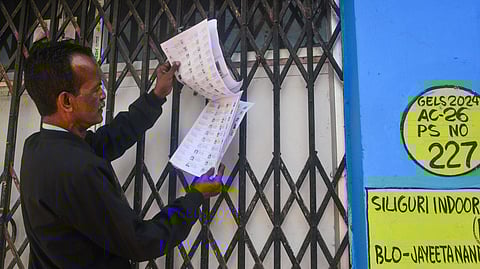 A voter checks his name in West Bengals draft electoral rolls after the list of valid voters were placed at the Siliguri Indoor stadium premises for the Special Intensive Revision (SIR) camps, in Siliguri on Friday