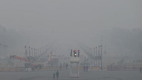 Visitors walk along the Kartavya Path amid smoggy condition in New Delhi on Wednesday.