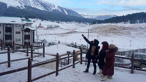Tourists pose for a selfie during the New Year celebrations, in Gulmarg, Thursday, Jan. 1, 2026.