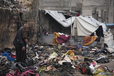 Fatima Abu al-Bayd inspects what remains of her mother’s tent after her mother, Amal Abu Al-Khair, and grandchild, Saud, were killed when it caught fire overnight at the Yarmouk displacement camp in Gaza City, Friday, Jan. 2, 2026. 