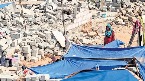 A woman walks to her make-shift tent, amidst the rubble caused by the demolition drive by BSWML at Kogilu Layout in Yelahanka.