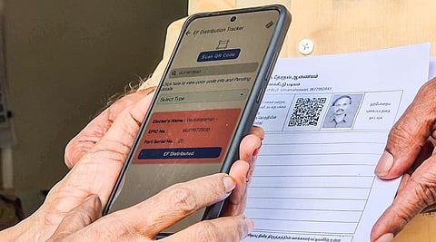 A Special Intensive Revision (SIR) official scans a form during the house-to-house verification process to update voter list, the exercise to verify and update India’s voter lists, in Tiruchirappalli on Tuesday.