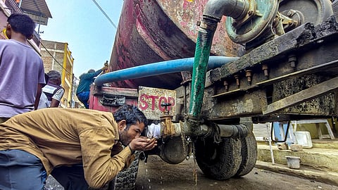 A man drinks water from a tanker amid a contaminated water crisis at Bhagirathpura, in Indore, Saturday, Jan. 3, 2026. 