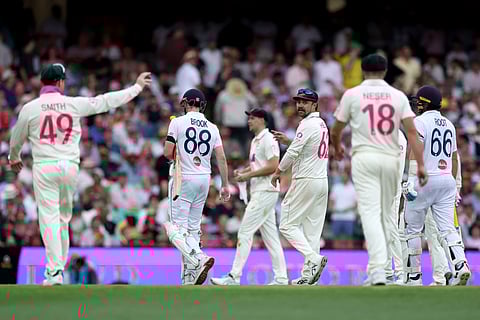 England’s Joe Root (R) and Harry Brook (2nd L) walk off the ground with Australian players as bad light stops play on day one of the fifth Ashes cricket Test match between Australia and England at the SCG in Sydney on January 4, 2026.