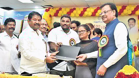 Social Welfare Minister Dr Swamy, along with the Prakasam district officials, distributing laptops to the students on Sunday.