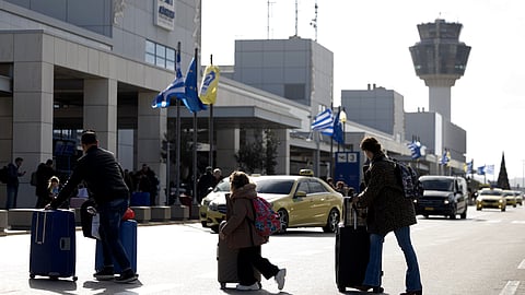 Passengers make their way to Athens' Eleftherios Venizelos international airport in Athens, Greece, Sunday, Jan. 4, 2026, as many flights were disrupted across Greece.