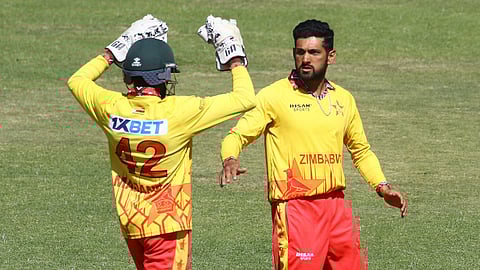 Zimbabwe's Sikandar Raza (R) celebrates with wicket keeper Clive Madande (L) after taking a wicket during the fifth T20 international cricket match played between Zimbabwe and India at Harare Sports Club in Harare on July 14, 2024.