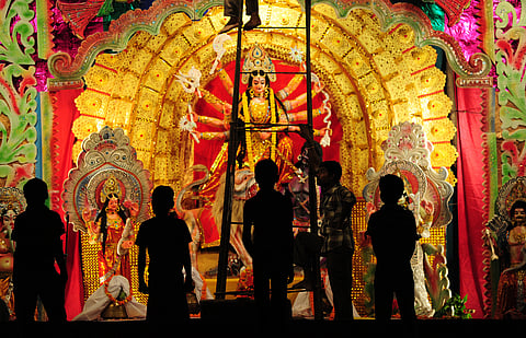 Artisans give the final touches to the idol of Goddess Durga.