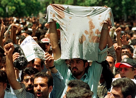 In this July 12, 1999 file photo, an unidentified student at a rally in Tehran, Iran, holds up bloody T-shirt of a friend who was injured sometime in the last few days during clashes between police and student demonstrators.