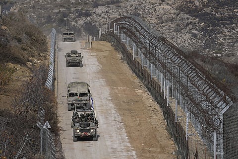 Israeli soldiers cross the security fence moving towards the so-called Alpha Line that separates the Israeli-annexed Golan Heights from Syria, in the town of Majdal Shams, Dec. 15, 2024