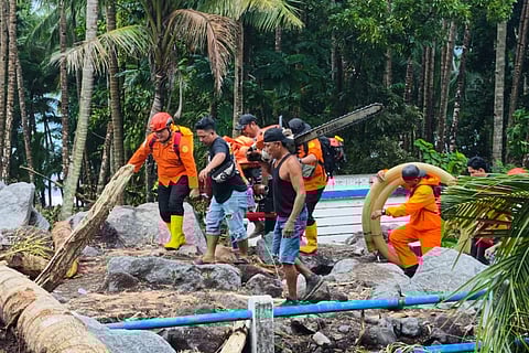 In this photo released by the Indonesian National Search and Rescue Agency (BASARNAS) on Tuesday, Jan 6, 2026, resccuers and villagers search for victims after flash floods hit Sitaro district of North Sulawesi province, Indonesia, 
