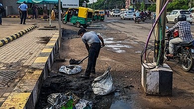 A man employed by Esplanade mall collects waste extracted by BMC workers from storm-water drain at Bomikhal In Bhubaneswar.