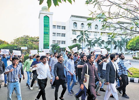 Students of the Maulana Azad National Urdu University shout slogans as they protest what they see as an attempt to acquire varsity land, on Wednesday